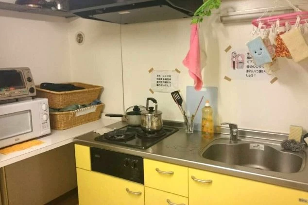 寮内のシャワールーム入口。白い扉が並び、清潔感のあるコンパクトな設計になっています。