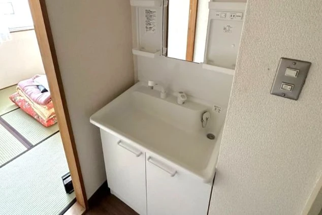 長野県軽井沢でのリゾートバイトの寮の独立洗面台の画像。奥には畳の部屋が見える。