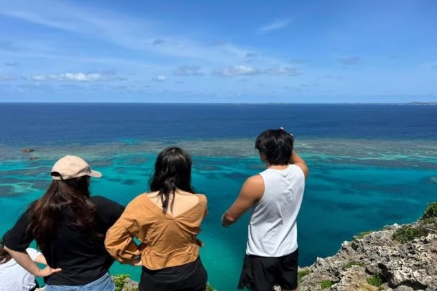 ワクトリでリゾートバイトをしているスタッフが撮影した、宮古島の海と3人の男女の後ろ姿の画像。リゾートバイトの休日を仲間と楽しむイメージ。