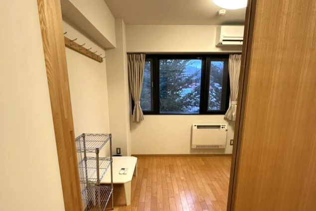 個室寮内部。窓からは軽井沢の豊かな自然が望め、エアコンや収納ラックも完備。