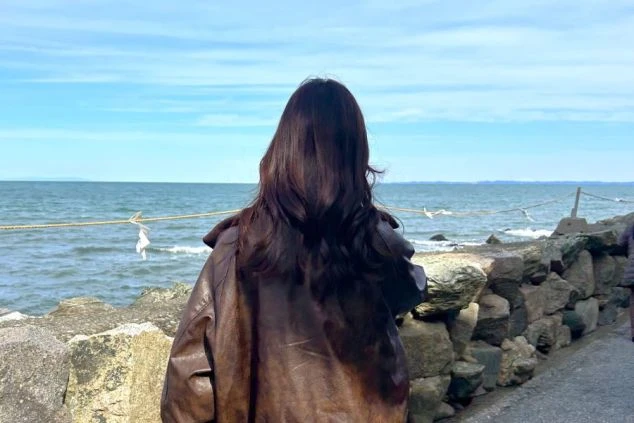 目の前に広がる青い海を眺める女性の画像。海沿いのリゾートバイトなら、仕事の合間や休日に最高の開放感を味わえる。