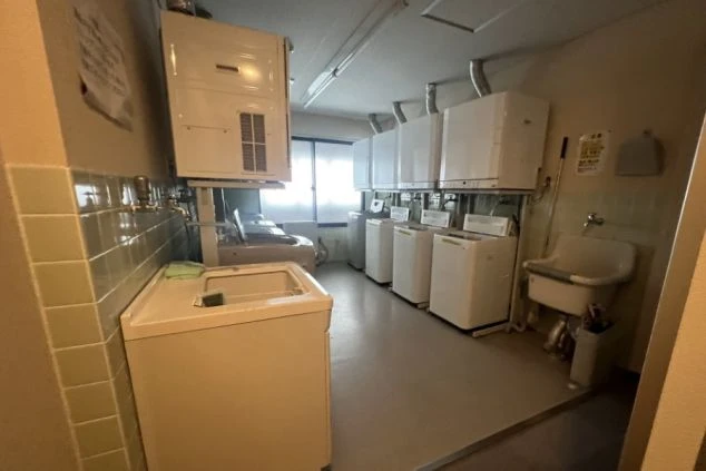 リゾートバイトの寮に設置されたランドリースペースの画像。たくさんの洗濯機と乾燥機が並んでいる。