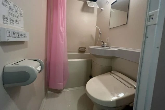 リゾートバイトの寮のユニットバスの画像。便座と洗面台、バスタブがまとまって配置されている。清潔感のある、リゾートバイトの寮の風呂場の画像。