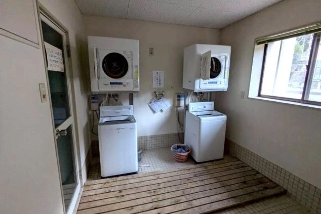 寮内にある共同の洗濯・乾燥機スペースの画像。複数台設置されている。