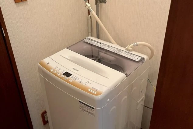家具家電付きリゾートバイトの寮。仕事着の洗濯に困らないよう、きれいで機能的な洗濯機が設置された設備。