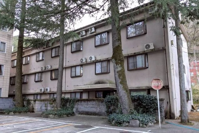 下呂温泉の豊かな緑に囲まれたスタッフ寮の外観画像。周囲は静かな環境で、歴史ある温泉街での仕事を支える落ち着いた居住拠点。