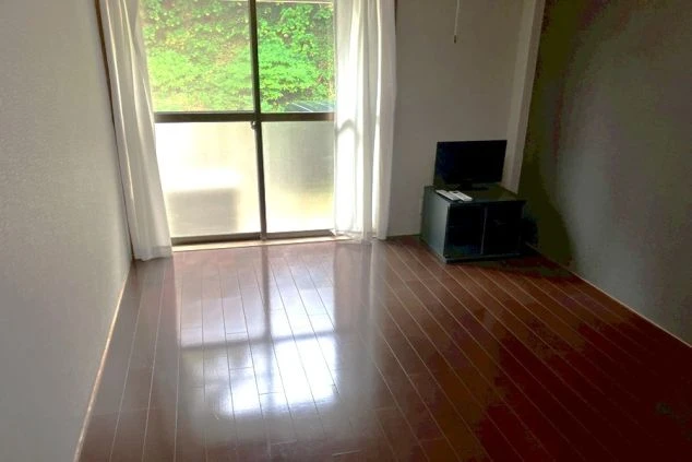 リゾートバイトの寮の個室。フローリングの部屋にテレビが完備された、シンプルなプライベート空間です。