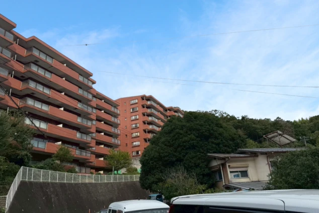 木々の向こうにそびえる、段々状のデザインが特徴的なホテル建物