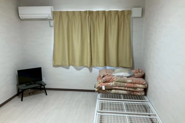 リゾートバイトの寮の個室。ベッド、布団、テレビ、エアコンが完備された、快適なプライベート空間です。