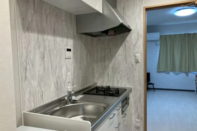 リゾートバイトの新築・築浅寮にあるキッチン。モダンなデザインで、シンクやコンロも完備。自炊も快適にできます。