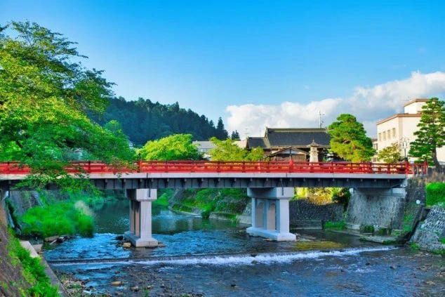 飛騨高山の観光名所、中橋（なかばし）。宮川に架かる赤い橋と、周囲の緑のコントラストが美しい、人気のフォトスポットです。