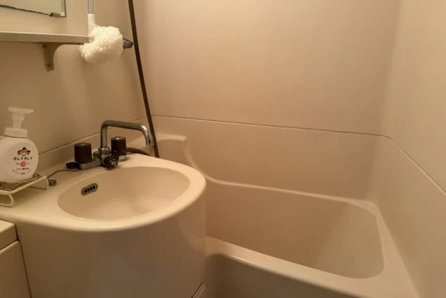 寮内の洗面台とシャワースペース。コンパクトにまとまった実用的な設備です。