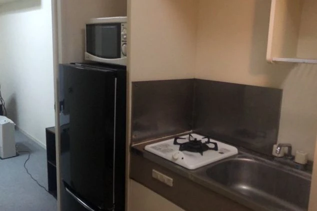 自炊可能なガスコンロ、シンク、冷蔵庫、電子レンジが完備されたミニキッチン。