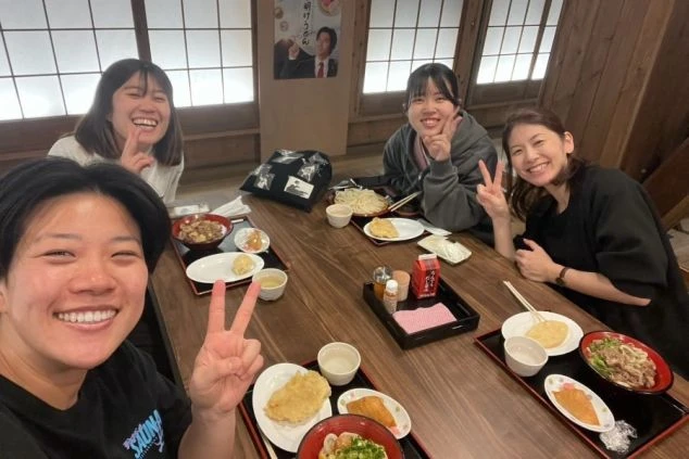 食事を囲んで楽しそうに語らう若者たち。リゾートバイトは、同じ場所で働く仲間と最高の思い出を作れる場所です。