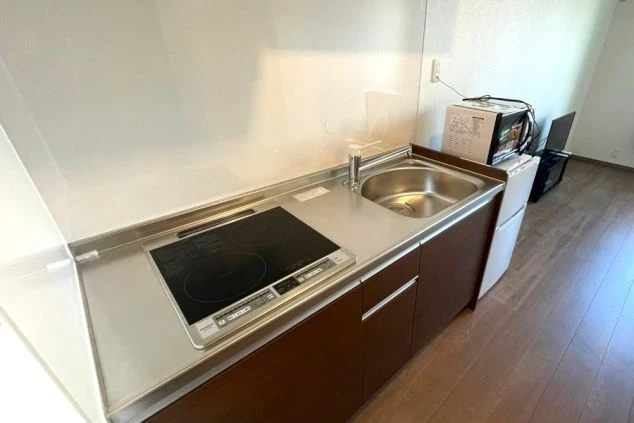 リゾートバイトの完全個室寮のキッチンの画像。電子レンジ・冷蔵庫も備え付けてある。