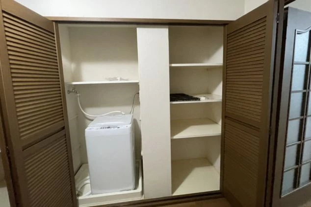 リゾートバイトの長期滞在に必須の、室内洗濯機付きの個室寮。扉付きの収納スペースに洗濯機と荷物用の棚が完備されており生活に便利。