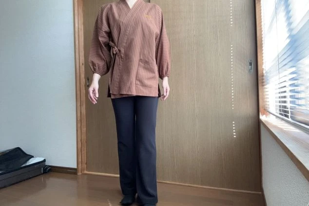 全般業務の制服。薄い茶色の作務衣を着用。