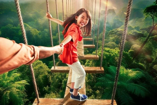 吊り橋を渡る、楽しそうな女の子。誰かと手をつなぎながら、ジャングルの中を歩いている。               分析