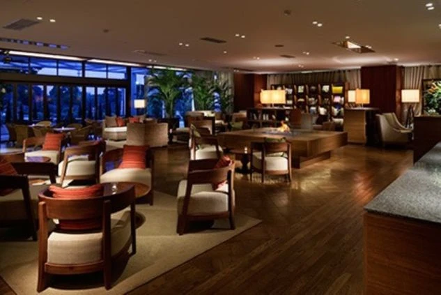 リゾートホテルの落ち着いたラウンジ。暖炉やソファーがあり、ゆったりと過ごせる空間。ホテルでのリゾートバイトの仕事風景。