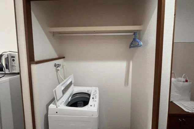リゾートバイトの寮の室内に設置された、洗濯機とクローゼット。自分専用なので、時間を気にせず利用できます。