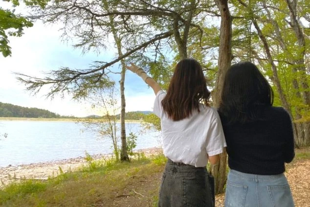 リゾートバイトの仲間と、湖畔の森を散策する二人の女性。仕事の休日には、近くの自然豊かなスポットでのんびり過ごすのもおすすめです。