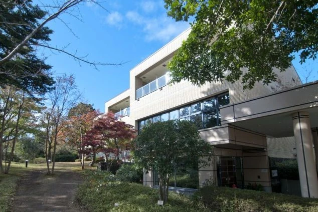 自然に囲まれたホテル外観の画像。緑豊かな木々の向こうに、モダンな建物が見えます。