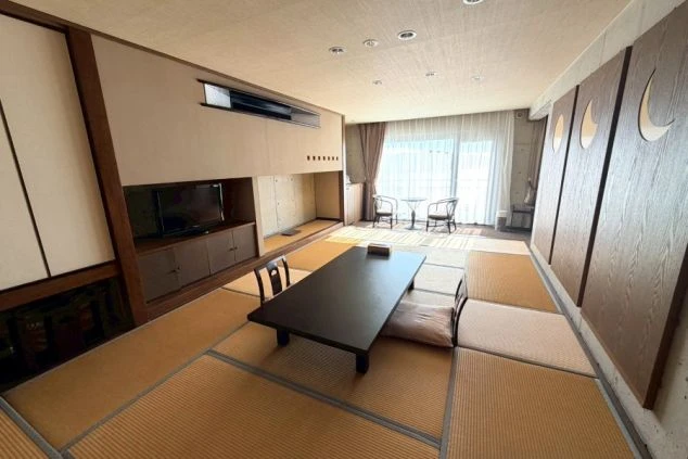 室を利用したリゾートバイト寮の室内(和洋室)。広々とした畳敷きの部屋とテーブル。