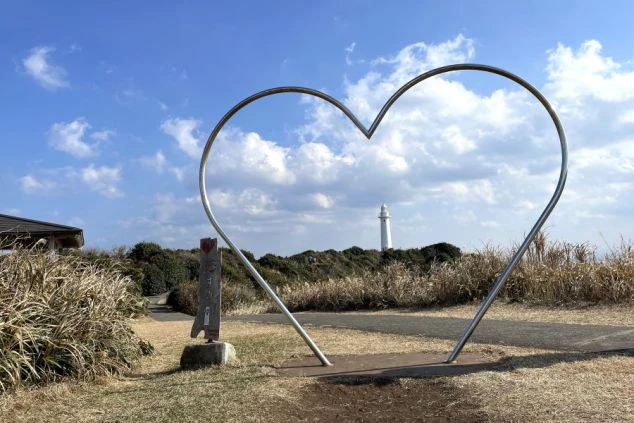 静岡県下田市の景勝地「爪木崎（つめきざき）」にある、白い灯台をフレームに収める大きなハート型のモニュメントの写真。