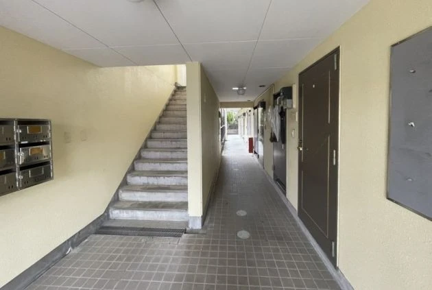 集合ポストと階段があり、清潔感が保たれたリゾートバイト寮の玄関。