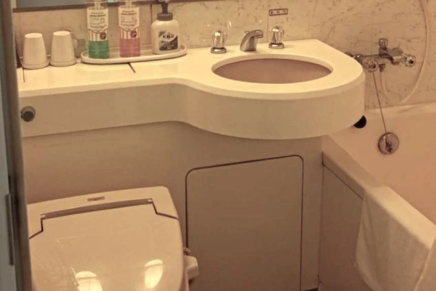 リゾートバイトの寮に備え付けられたユニットバスの画像。バスタブと便座、洗面台がまとまって配置されている。清潔感のある、寮の風呂場の画像。