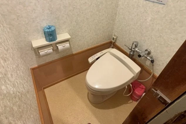 リゾートバイトの寮のトイレの画像。ウォシュレット付きの便座と、トイレットペーパーが備え付けられている。清潔感があり、快適に利用できるトイレの画像。