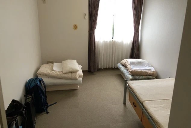 リゾートバイトの社員寮の部屋を表現するイメージ画像。ベッドが2つ置かれたシンプルな個室。