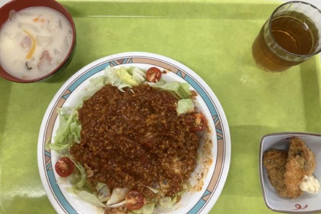 タコライスのような料理。付け合わせとして、クリームスープ、カキフライ、そして飲み物がある。