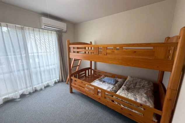 寮の部屋。木製の二段ベッドが置かれた部屋。