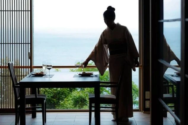 オーシャンビューの客室で、お客様にワインをサーブする仲居スタッフ。リゾートバイトでは、こうした上質なおもてなしのスキルを身につけることができます。