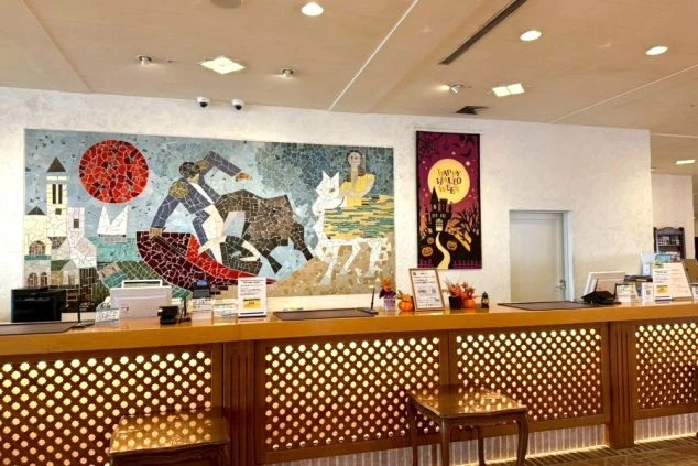 フロントカウンター。背後の壁面には、闘牛士や馬に乗る女性を描いた鮮やかな大型のモザイクタイルアートが飾られています。