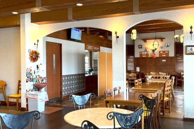 志摩スペイン村内にあるレストラン「アミーゴ」の店内。木の温もりを感じるテーブル席と、アーチ状の壁が特徴的な落ち着いた空間。