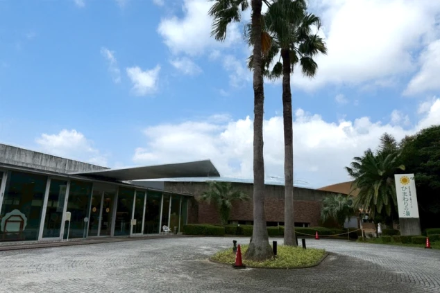 高く伸びた2本のヤシの木と、モダンなデザインの建物が特徴的です。