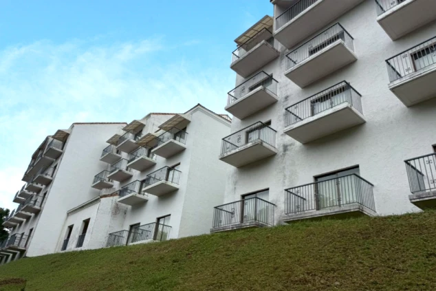 白い外壁に、規則的に並んだアイアンの手すり付きバルコニーが印象的なホテルの外観。