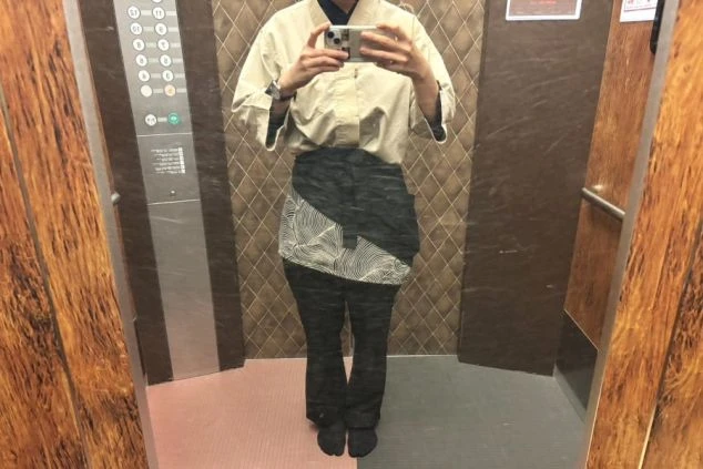エレベーターの中で、和風の制服を着用したスタッフが自撮りをしている画像。旅館や和食レストランでのリゾートバイトの仕事内容を表す、制服の画像。