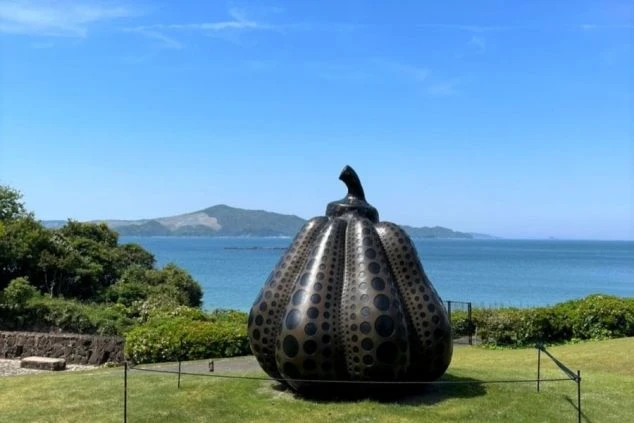 青い海と空を背景に、草間彌生氏のドット柄の巨大なカボチャのオブジェが置かれている。