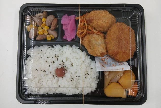 ご飯にコロッケ、スパゲッティ、煮物などが詰まったお弁当。