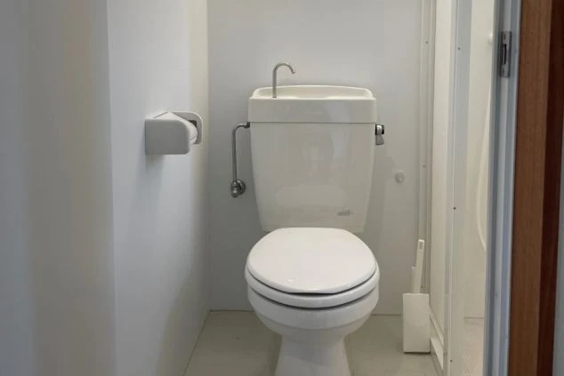 ワクトリの社員が出張で撮影した、リゾートバイトの寮のトイレの画像。手洗い器付きの洋式トイレで、シンプルかつ清潔感のある空間。リゾートバイト中の生活環境を示す設備の一つ。