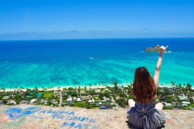 高台からの透き通るような海と街並みを一望する女性