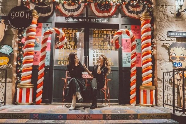   アメリカンな装飾が施された「OKINAWA MARKET DEPOT ISLAND」の前で、楽しそうに談笑する2人の女性