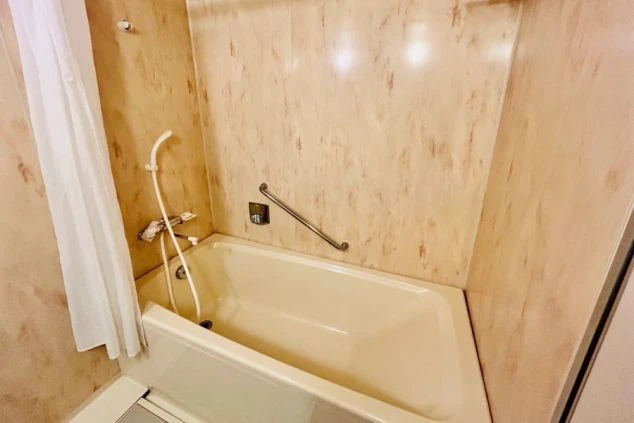 リゾートバイトの寮に完備された清潔な浴室。浴槽とシャワーがあり、仕事の疲れを快適に癒せるプライベート空間。