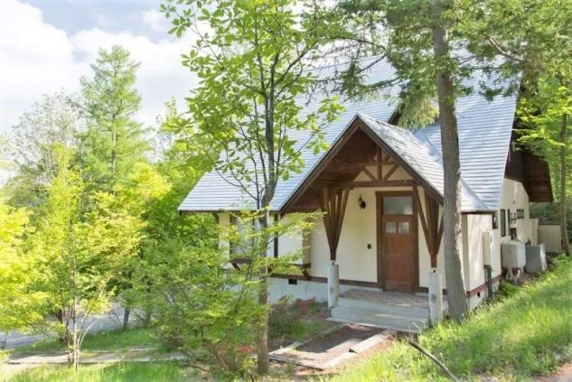 長野県安曇野市の、緑に囲まれたコテージの画像。