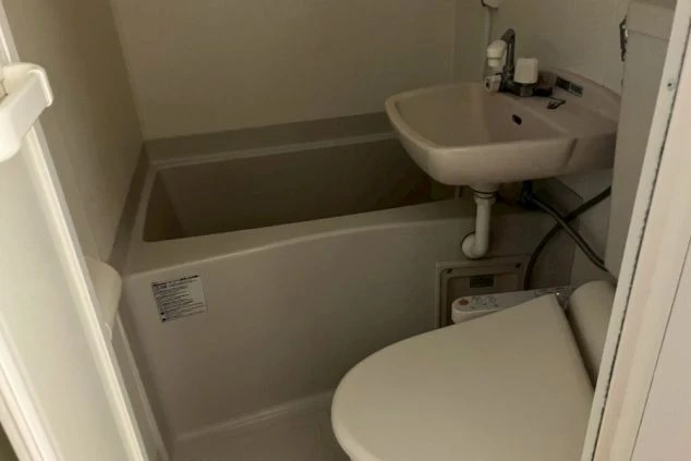 寮のユニットバス。浴槽、洗面台、温水洗浄便座付きトイレが一体となったコンパクトな浴室。