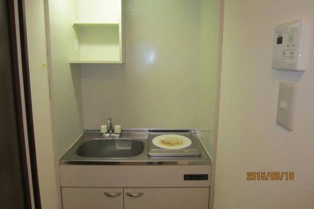 リゾートバイト寮のミニキッチン。一口電気コンロとシンクがあり、簡単な自炊が可能です。