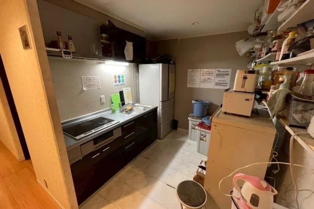 複数の洗面台と鏡がある共用洗面所。部屋の壁は花柄の壁紙で、床はタイル敷きだ。